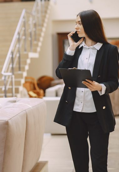 Girl in a office. Woman in a black suit. Lady with folder.